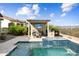 Outdoor oasis featuring a pool with waterfall feature, outdoor kitchen, and shaded dining area at 5033 N 205Th Gln, Buckeye, AZ 85396