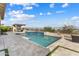 Spacious backyard featuring a pool, spa, outdoor kitchen, dining area, and landscaped surroundings at 5033 N 205Th Gln, Buckeye, AZ 85396