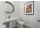 Chic powder room featuring modern fixtures, unique lighting, and a stylish round mirror at 5033 N 205Th Gln, Buckeye, AZ 85396