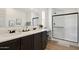 Elegant bathroom with double vanity, sleek dark cabinets, and a modern glass-enclosed shower at 51134 W Bluejay St, Maricopa, AZ 85139