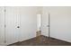 Clean bedroom with carpet and white walls, with an open door to a closet or en-suite bathroom at 51134 W Bluejay St, Maricopa, AZ 85139