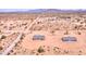 An aerial view of desert homes on a large lot with mountain views in the distance at 51942 W Sotol Rd, Maricopa, AZ 85139