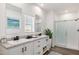 Modern bathroom features double sinks, marble counters, framed mirrors and a glass enclosed shower at 51942 W Sotol Rd, Maricopa, AZ 85139
