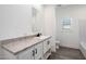Bright bathroom featuring granite countertops, modern fixtures, framed mirror and natural light at 51942 W Sotol Rd, Maricopa, AZ 85139