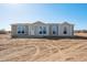 New single-story home boasts a symmetrical design and a freshly landscaped yard under a clear blue sky at 51942 W Sotol Rd, Maricopa, AZ 85139