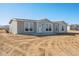 New single-story home boasts a symmetrical design and a freshly landscaped yard under a clear blue sky at 51942 W Sotol Rd, Maricopa, AZ 85139