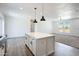 Modern kitchen features a central island, pendant lighting, and sleek wood flooring at 51942 W Sotol Rd, Maricopa, AZ 85139