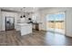 Bright, modern kitchen features stainless steel appliances, center island, and sliding glass doors at 51942 W Sotol Rd, Maricopa, AZ 85139