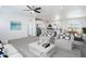 Bright, open-concept living room features modern ceiling fan, updated decor, and flows seamlessly into the kitchen at 51942 W Sotol Rd, Maricopa, AZ 85139