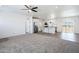 Open-concept living space with modern ceiling fan, white walls, and view of the kitchen with island at 51942 W Sotol Rd, Maricopa, AZ 85139