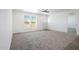 Bright living room features large window and neutral carpet, offering a clean, minimalist aesthetic at 51942 W Sotol Rd, Maricopa, AZ 85139