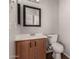 The powder room features a toilet and wood vanity with a white sink and bronze fixtures at 5232 N 16Th Ln, Phoenix, AZ 85015