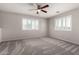 Bright bedroom featuring neutral walls, carpet flooring, modern ceiling fan and shuttered windows at 5232 N 16Th Ln, Phoenix, AZ 85015