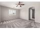 Carpeted bedroom with modern ceiling fan, shuttered windows, and an open doorway to the rest of the house at 5232 N 16Th Ln, Phoenix, AZ 85015