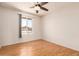 Cozy bedroom with fan, laminate flooring, and a window offering neighborhood views at 5320 W Maui Ln, Glendale, AZ 85306