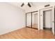 Bedroom with laminate flooring, fan, and mirrored closet at 5320 W Maui Ln, Glendale, AZ 85306