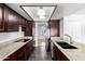 Galley kitchen features granite countertops, dark cabinets, stainless appliances, and stylish lighting at 5320 W Maui Ln, Glendale, AZ 85306