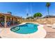 Sparkling blue pool with tanning ledge and covered patio create a relaxing outdoor oasis at 5320 W Maui Ln, Glendale, AZ 85306