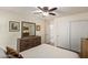 Cozy bedroom featuring a wooden dresser and mirror, white sliding closet doors and neutral colored walls at 6002 N 124Th Dr, Litchfield Park, AZ 85340