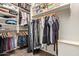 Organized walk-in closet with hanging clothes, shelving, and dark wood flooring for ample storage at 6002 N 124Th Dr, Litchfield Park, AZ 85340