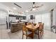 Beautiful kitchen with black cabinets, stone island, stainless steel appliances, and adjacent dining area at 6002 N 124Th Dr, Litchfield Park, AZ 85340