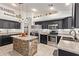 Modern kitchen with black cabinets, stainless steel appliances, and stylish island with stone accents at 6002 N 124Th Dr, Litchfield Park, AZ 85340