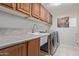 Functional laundry room featuring ample counter space, a utility sink, and modern washer and dryer at 6002 N 124Th Dr, Litchfield Park, AZ 85340