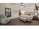 Serene main bedroom with wood floors, large windows, a comfortable chair, and a soothing color palette at 6002 N 124Th Dr, Litchfield Park, AZ 85340