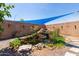 Relaxing water feature with waterfall, shade cover, and lush plants in a private backyard setting at 6002 N 124Th Dr, Litchfield Park, AZ 85340
