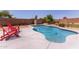 Sparkling pool with lounge chairs, concrete decking and privacy wall in a landscaped backyard at 6002 N 124Th Dr, Litchfield Park, AZ 85340