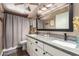 Bathroom featuring a double sink vanity with marble countertops and a framed mirror at 605 S Monterey St, Gilbert, AZ 85233