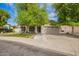 Charming home featuring a well-maintained lawn, mature trees, and a spacious two-car garage, enhancing curb appeal at 605 S Monterey St, Gilbert, AZ 85233
