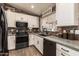 Well-appointed kitchen with white cabinetry, black appliances, stylish backsplash, and plenty of natural light at 605 S Monterey St, Gilbert, AZ 85233