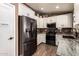 Modern kitchen featuring white cabinetry, black appliances, stylish backsplash, and pantry, perfect for culinary enthusiasts at 605 S Monterey St, Gilbert, AZ 85233