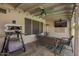 Relaxing covered patio with comfortable seating, barbecue, mounted television, and ceiling fan at 605 S Monterey St, Gilbert, AZ 85233