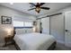 Cozy bedroom featuring a ceiling fan, a window, and a sliding barn door to the closet at 6413 E Parkview Dr, Scottsdale, AZ 85257