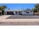 Charming one-story home showcasing a dark gray garage door, rock landscaping, and a well-maintained lawn at 6413 E Parkview Dr, Scottsdale, AZ 85257