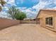 Spacious gravel backyard surrounded by a block wall and the exterior of the home at 7037 W Cavalier Dr, Glendale, AZ 85303