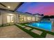 Backyard swimming pool with modern design elements, turf, and outdoor kitchen at 8549 E Indianola Ave, Scottsdale, AZ 85251