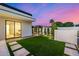 Beautiful backyard with artificial grass, stepping stones and a modern-style bedroom entrance at 8549 E Indianola Ave, Scottsdale, AZ 85251