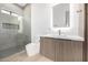 Modern bathroom featuring a glass-enclosed shower with gray tiling and a vanity with a backlit mirror at 8549 E Indianola Ave, Scottsdale, AZ 85251