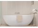 Freestanding white bathtub features sleek fixtures and a decorative side table at 8549 E Indianola Ave, Scottsdale, AZ 85251