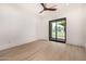 Spacious bedroom with a ceiling fan, wood-look tile flooring, and sliding glass doors to a patio and yard at 8549 E Indianola Ave, Scottsdale, AZ 85251
