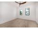 Bedroom with modern ceiling fan, hardwood floors, and two large windows at 8549 E Indianola Ave, Scottsdale, AZ 85251