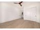 Bright bedroom with a ceiling fan, wood-look tile flooring, closet doors, and an en-suite bathroom at 8549 E Indianola Ave, Scottsdale, AZ 85251
