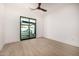 Bright bedroom with a ceiling fan, wood-look tile flooring, and sliding glass doors to the backyard patio at 8549 E Indianola Ave, Scottsdale, AZ 85251