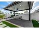 Outdoor kitchen features a modern stainless steel grill under a covered patio with a ceiling fan, perfect for entertaining at 8549 E Indianola Ave, Scottsdale, AZ 85251