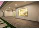 Outdoor patio with concrete floors, artificial turf, and a view into the dining room through a large window at 8549 E Indianola Ave, Scottsdale, AZ 85251