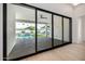 View of the outdoor pool and landscaped backyard through open glass doors, creating an seamless indoor-outdoor connection at 8549 E Indianola Ave, Scottsdale, AZ 85251