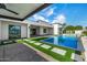 Stunning backyard with a modern pool, lush green turf, and stepping stone pathway to the outdoor living space at 8549 E Indianola Ave, Scottsdale, AZ 85251